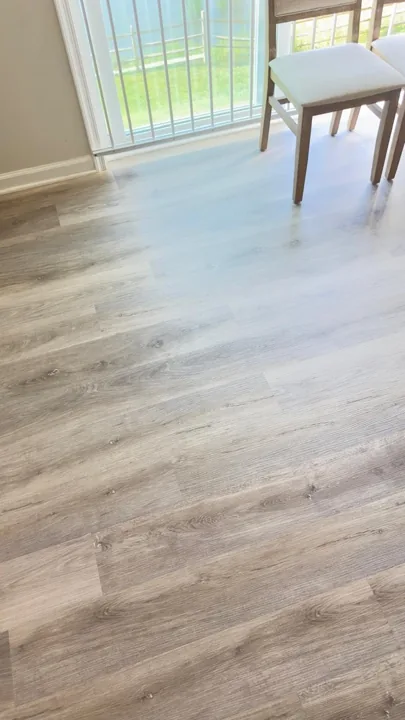 Gray-brown plank flooring beside a sliding glass door