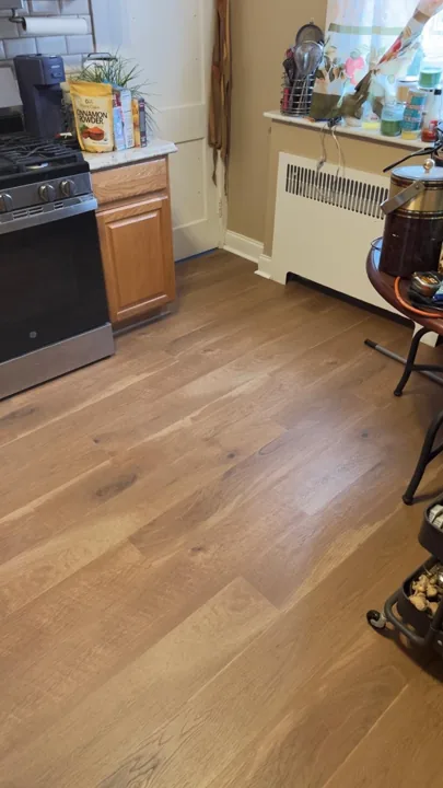 Wide warm-toned planks connecting residential rooms