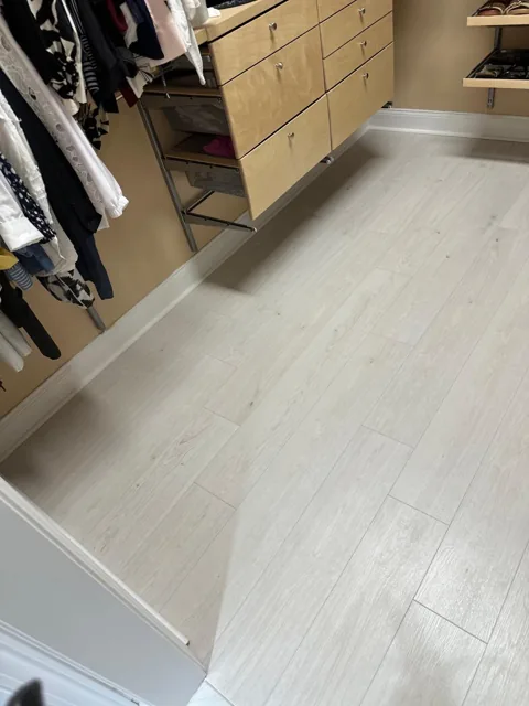 Pale plank flooring around built-in closet drawers