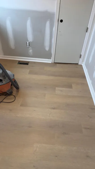 Pale wide-plank vinyl flooring during an interior renovation — work in progress