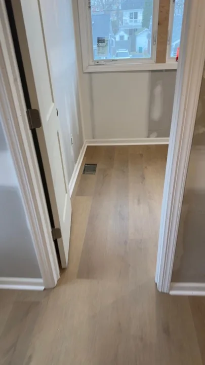 Pale wide-plank vinyl flooring during an interior renovation — work in progress