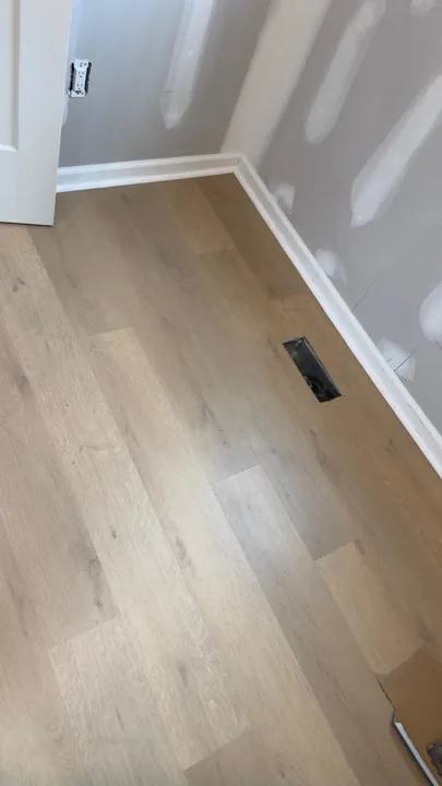 Pale wide-plank vinyl flooring during an interior renovation — work in progress