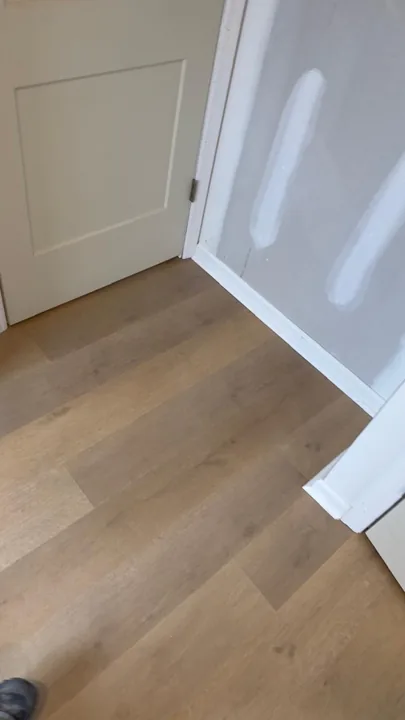 Pale wide-plank vinyl flooring during an interior renovation — work in progress