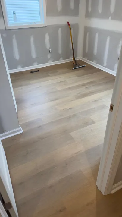 Pale wide-plank vinyl flooring during an interior renovation — work in progress