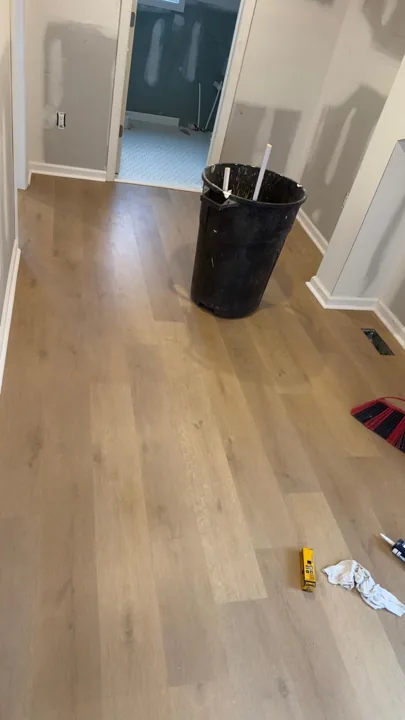 Pale wide-plank vinyl flooring during an interior renovation — work in progress