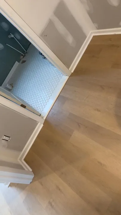 Pale wide-plank vinyl flooring during an interior renovation — work in progress