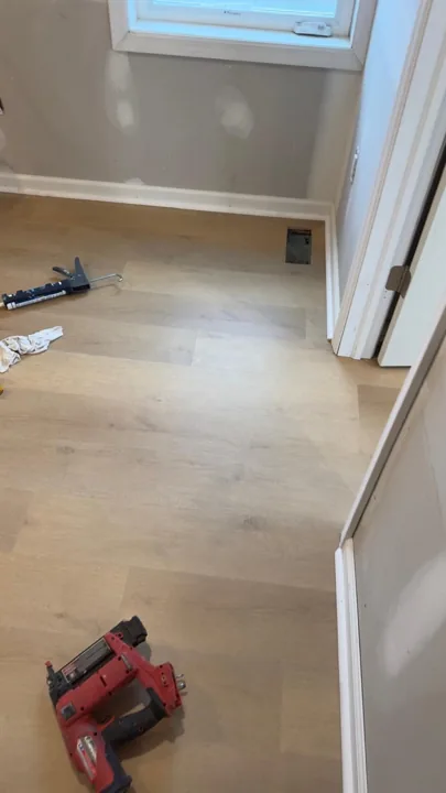 Pale wide-plank vinyl flooring during an interior renovation — work in progress