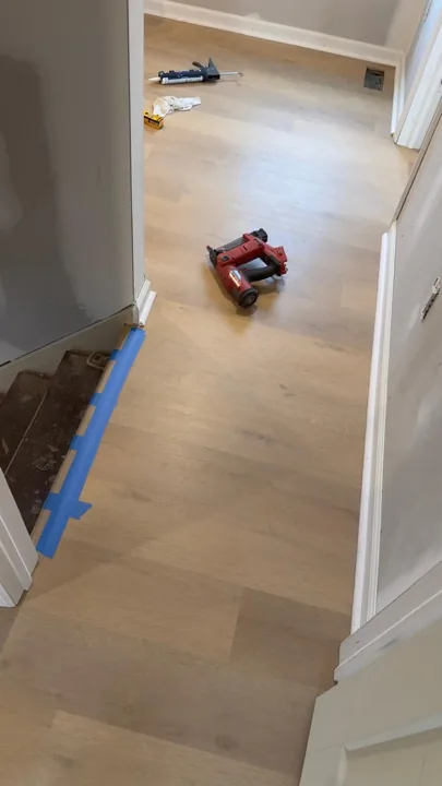 Pale wide-plank vinyl flooring during an interior renovation — work in progress
