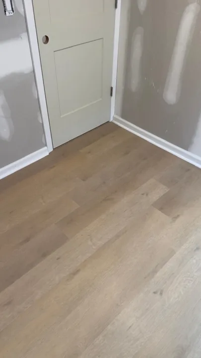 Pale wide-plank vinyl flooring during an interior renovation — work in progress