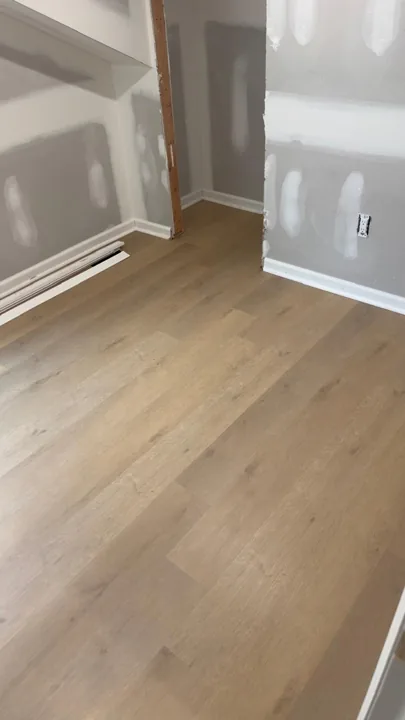 Pale wide-plank vinyl flooring during an interior renovation — work in progress