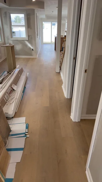 Pale wide-plank vinyl flooring during an interior renovation — work in progress