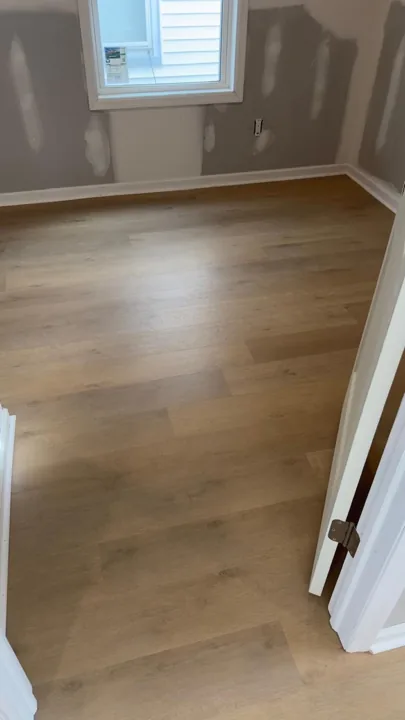 Pale wide-plank vinyl flooring during an interior renovation — work in progress