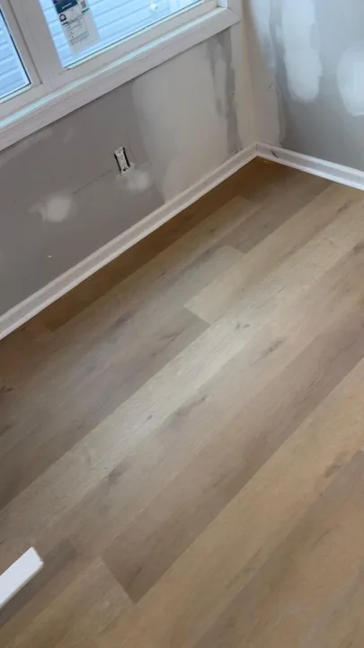 Pale wide-plank vinyl flooring during an interior renovation — work in progress
