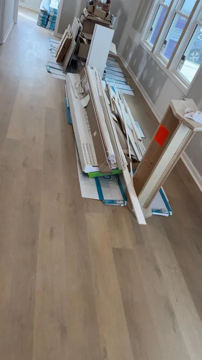 Pale wide-plank vinyl flooring during an interior renovation — work in progress