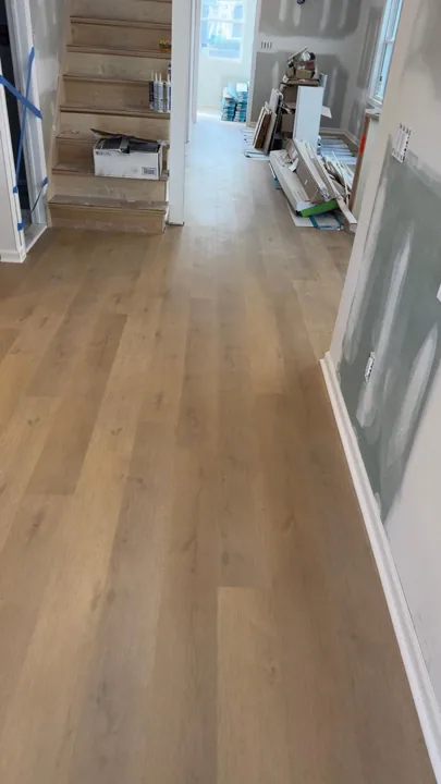 Pale wide-plank vinyl flooring during an interior renovation — work in progress